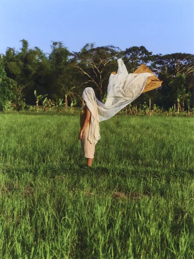 Woman in Field with Flowing Fabric - Woman in green field with wind-blown fabric