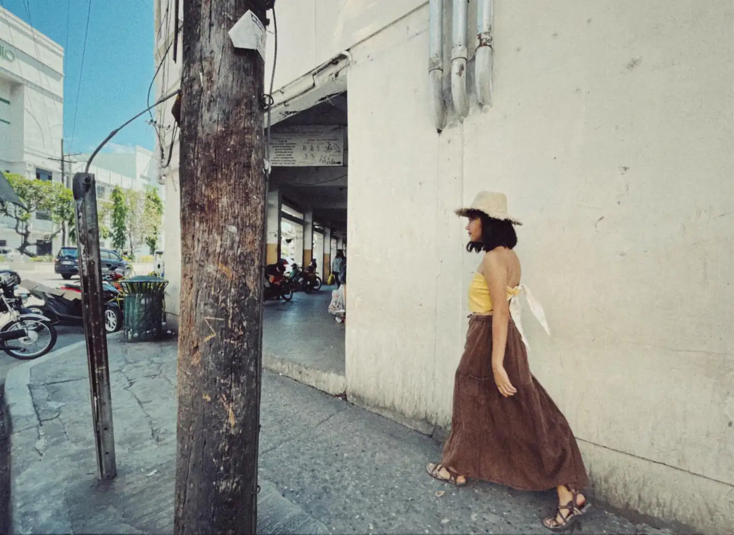 Woman Walking in City Street - Woman in yellow top and brown skirt walking away